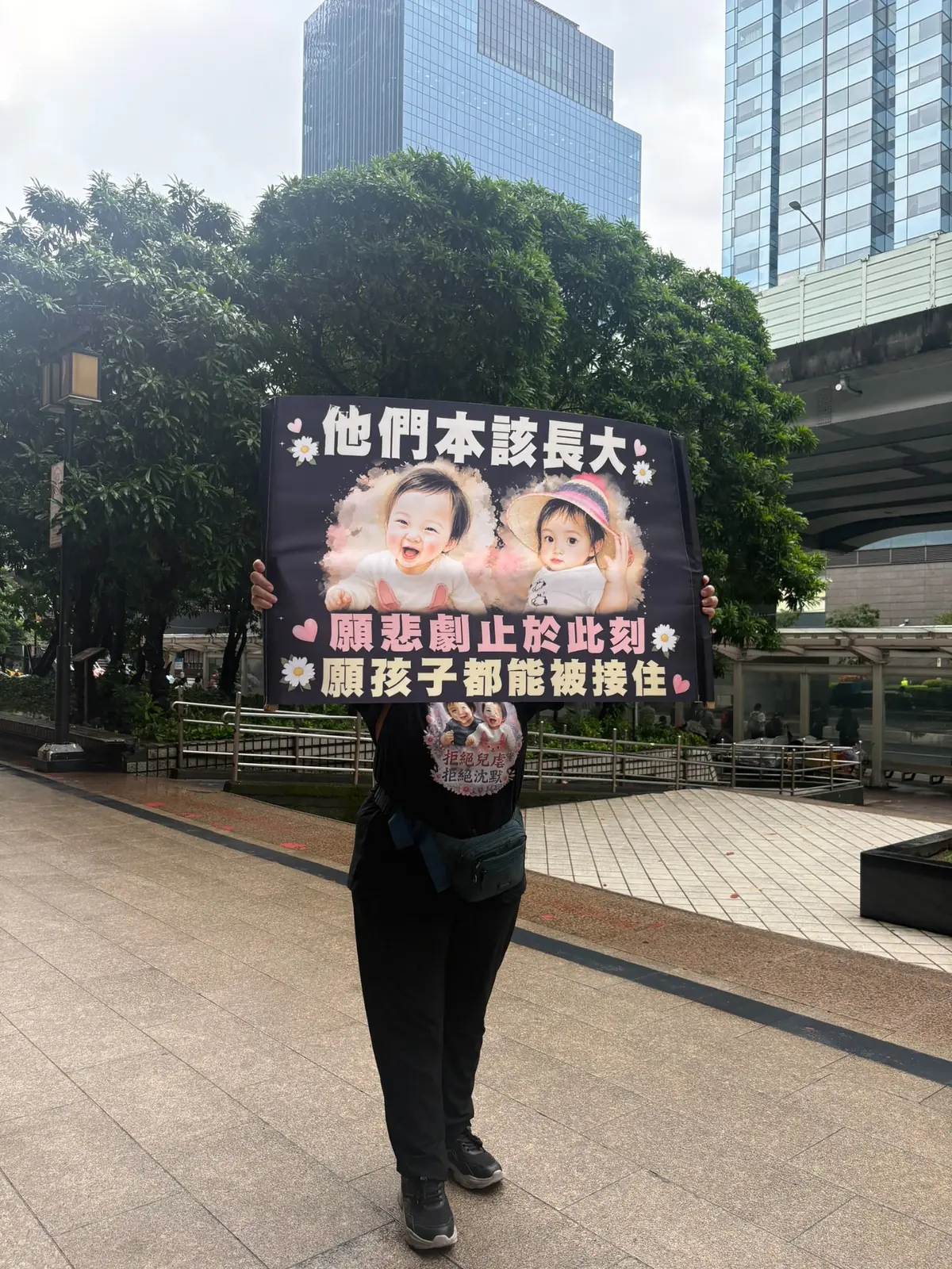參與者手持他們本該長大、願悲劇止於此刻、願孩子都能被接住的倡議牌
