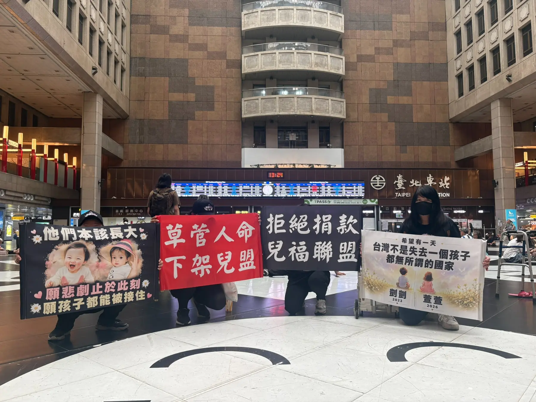 護童行動聯盟成員在臺北車站大廳手持四面兒少保護倡議牌